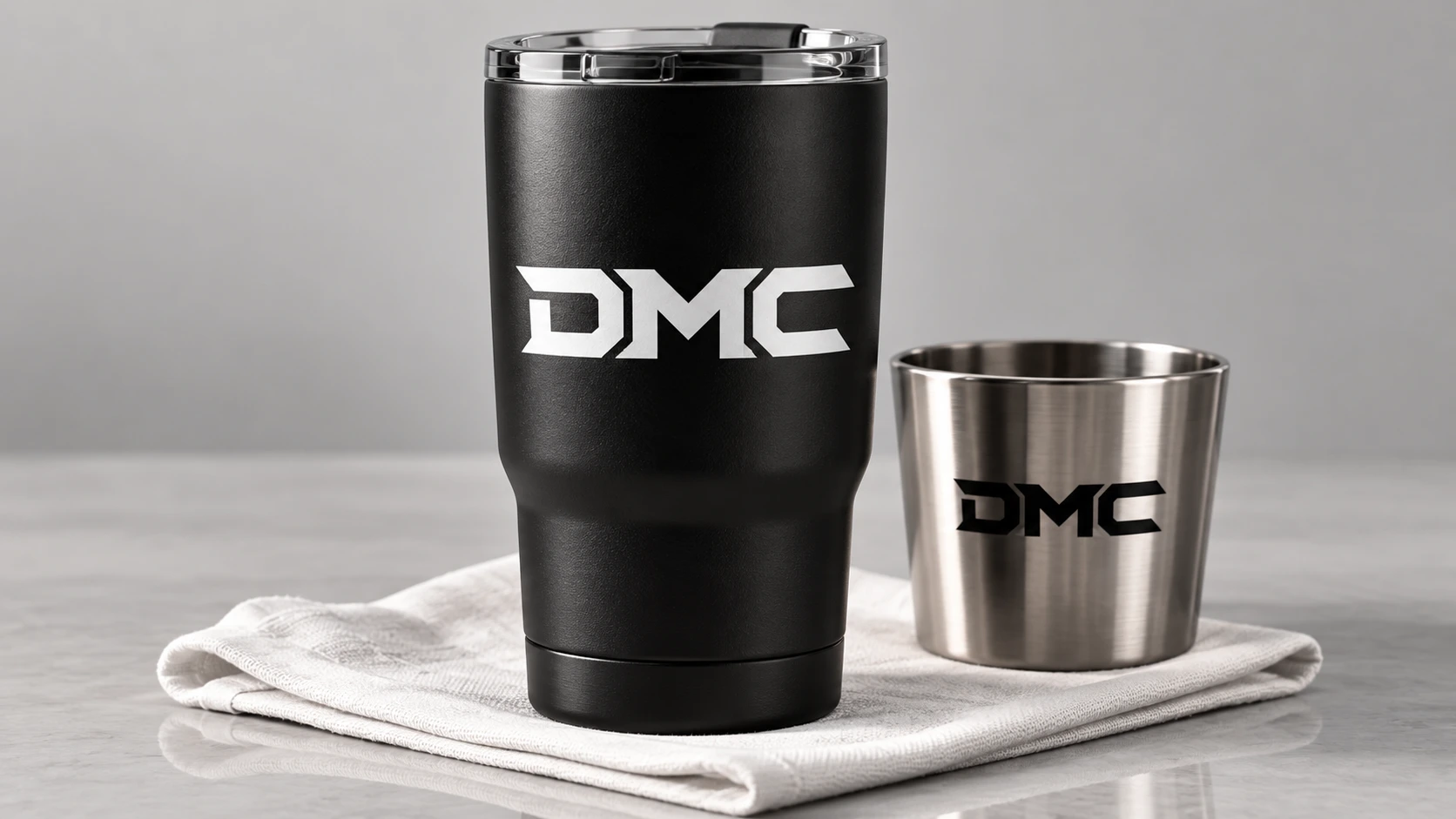 DMC merchandise concept on matte black and brushed steel drinkware